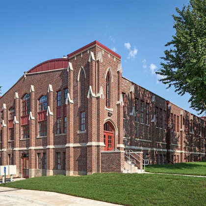 a large red brick building with arched windows and a red door.
