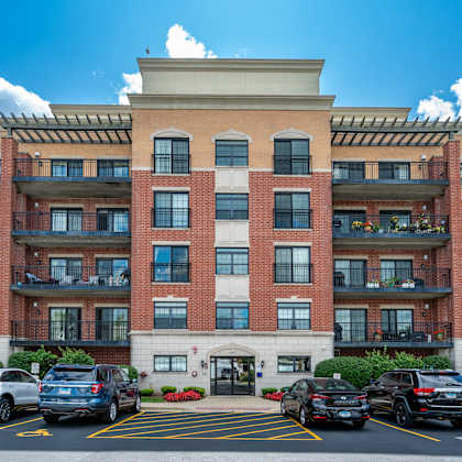 a large red brick building with a parking lot in front.