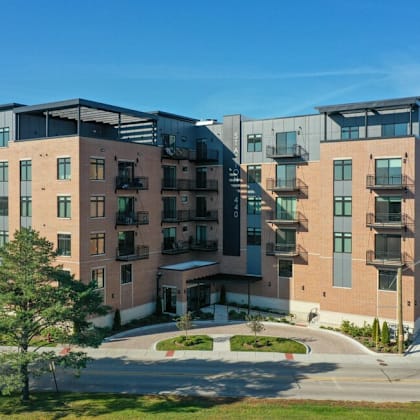 a brick apartment building with balconies and a sidewalk