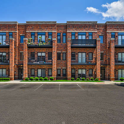 a large red brick building with a parking lot in front.