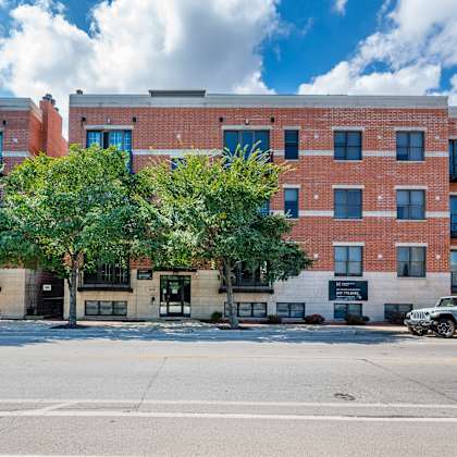 a red brick building with a black car parked in front.