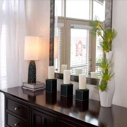 a table with candles and a mirror in front of a window
