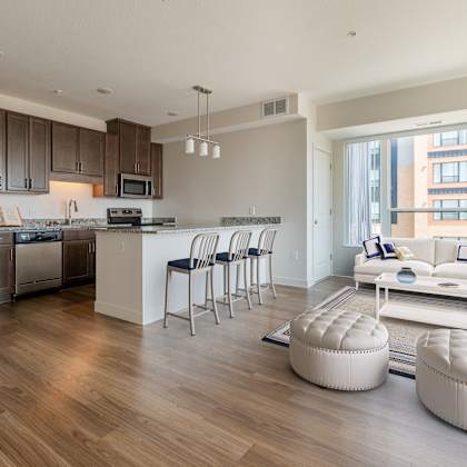 a living room and kitchen with wood flooring and a large window at sonder house, brooklyn center, mn