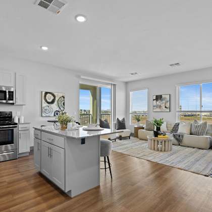 a modern kitchen with a large island and stainless steel appliances at copa flats apartments, maricopa