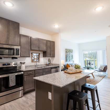 an open kitchen with stainless steel appliances and a granite counter top