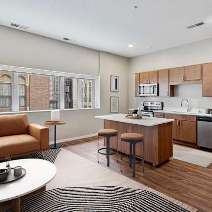 a living room with a kitchen and a couch at press house apartments, st paul