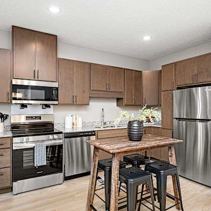 a modern kitchen with wooden cabinets and stainless steel appliances.