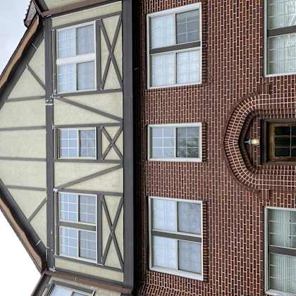 the side of a building with a triangular facade and windows