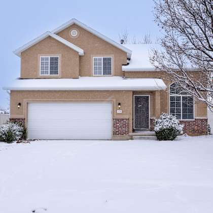 a house with a white garage door and a brown roof.