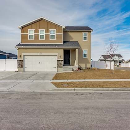 a two-story house with a garage is situated in a residential area.
