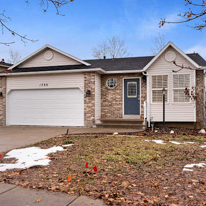 a house with a grey garage door and a black front door.