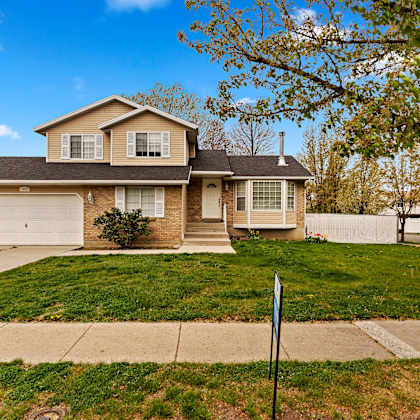 a house with a lawn and a sidewalk in front of it