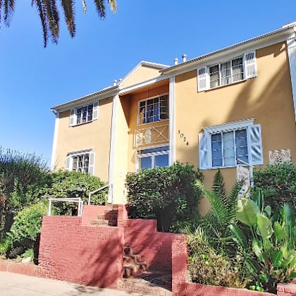 a house with a staircase and a palm tree in front of it