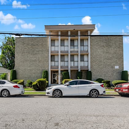 three cars are parked in front of a building.