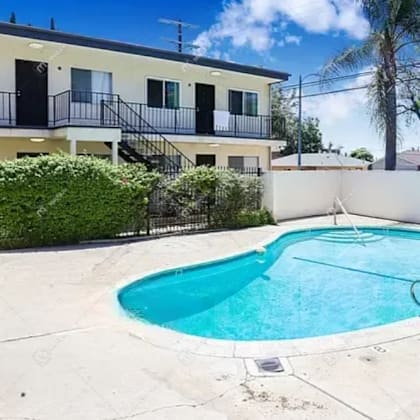 a swimming pool with a house in the background