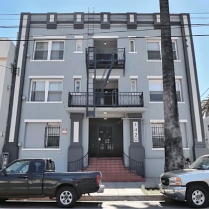 a grey building with a black truck parked in front.