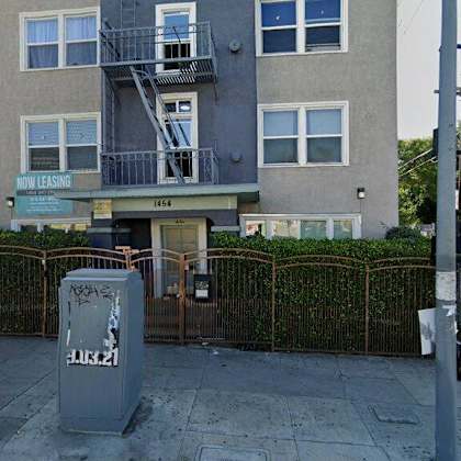 an apartment building with a parking meter in front of it