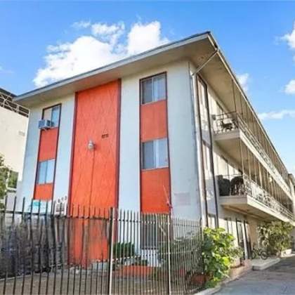 a building with orange doors and a fence in front of it