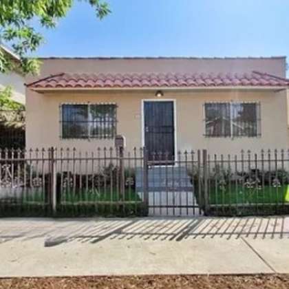 a house with a fence and a gate in front of it
