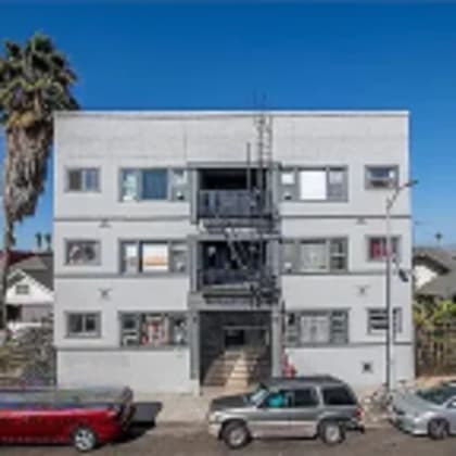 a large white building with cars parked in front of it