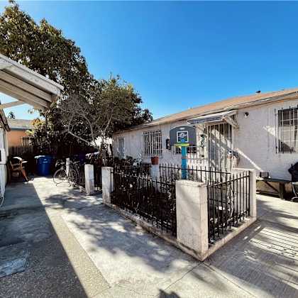 a small house with a driveway and a gate