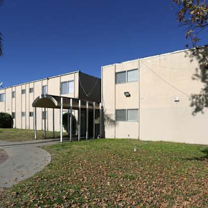 the exterior of an office building with a sidewalk and grass
