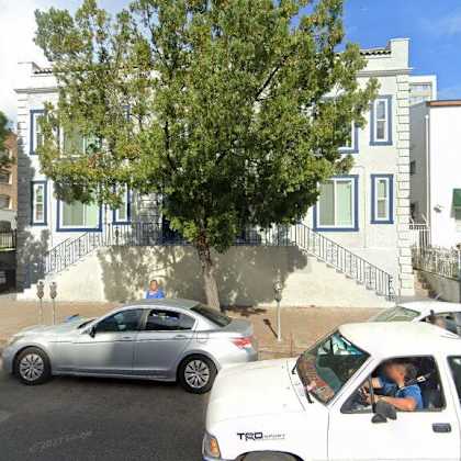 two cars parked on a street in front of houses