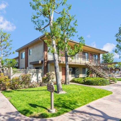 a house with a sidewalk and trees in front of it