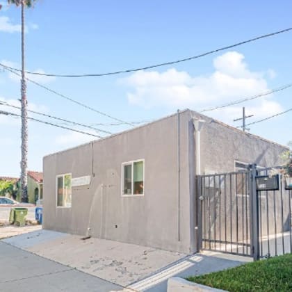 a small concrete building with a gate in front of it.