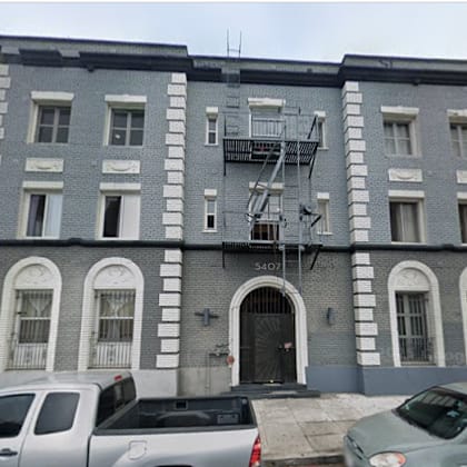 a grey building with a fire escape on the second floor.