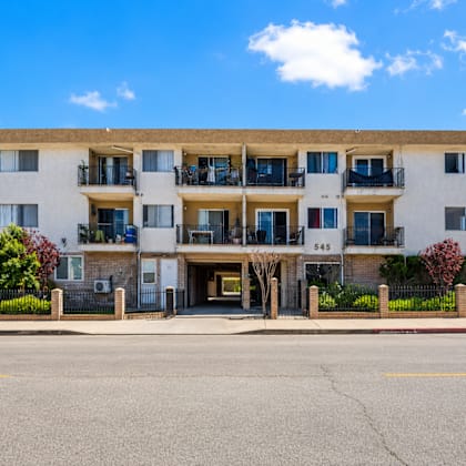 a large white building with balconies and the number 545 on it.