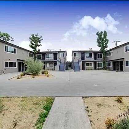 an empty parking lot in front of several apartment buildings