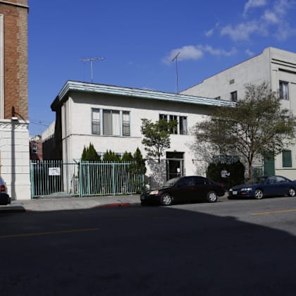a white building on a city street with cars