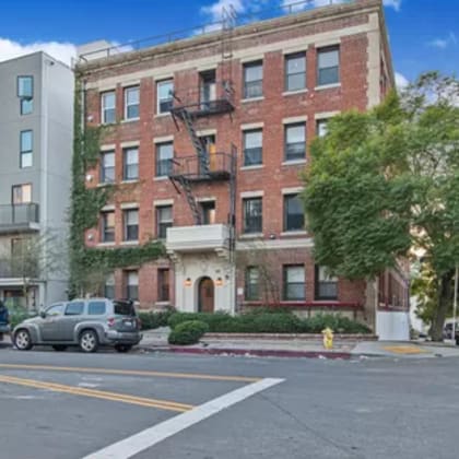 an apartment building on a city street with parked cars
