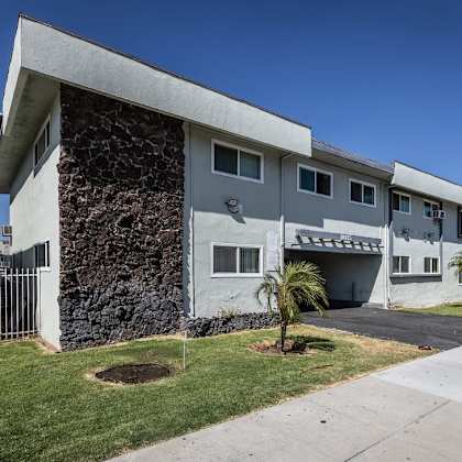 a modern house with a stone wall on the side.