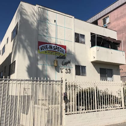 a building with a sign on the side of it behind a fence