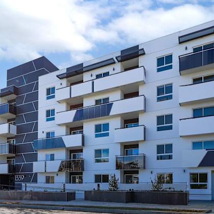a modern white apartment building with black and blue accents.
