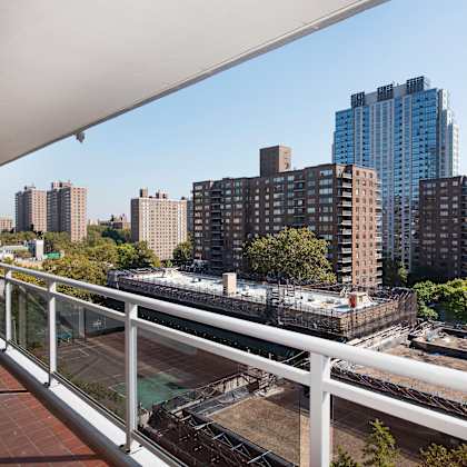 a balcony overlooks a cityscape with a mix of residential and commercial buildings.