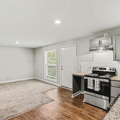 a kitchen with a stove top oven and a sink.