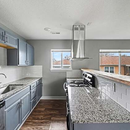 a kitchen with a granite countertop and stainless steel appliances.