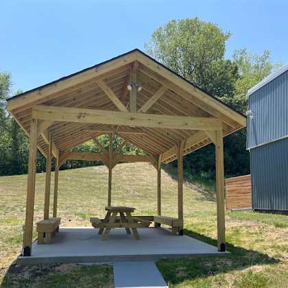 a picnic pavilion with a picnic table on a concrete slab