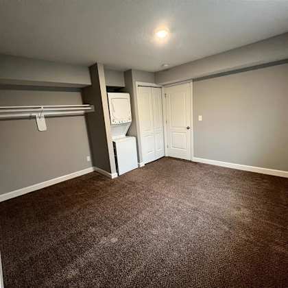 a bedroom with an open closet and washer and dryer