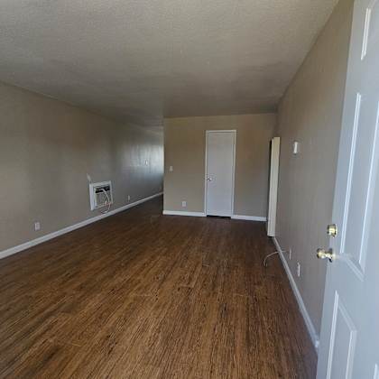 a room with wood flooring and white walls.