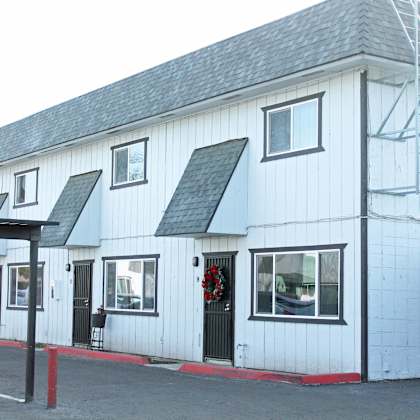a white building with a grey roof and a red line on the ground.