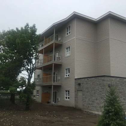 a large apartment building with a tree in front of it