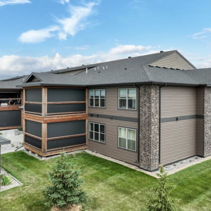 an aerial view of an apartment building with brown and black siding