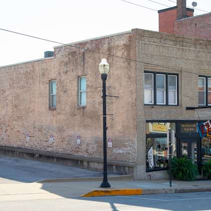 a street view of a building with a car parked in front.