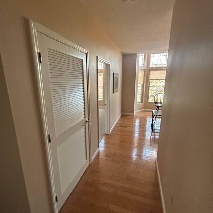 a long, narrow room with a window and a vent on the floor.