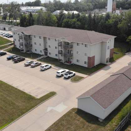 an aerial view of an apartment building and parking lot