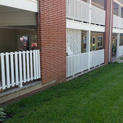 a view of the outside of a building with a white fence